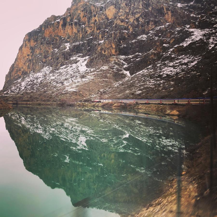 Diamond shaped image of a train in the mountains.